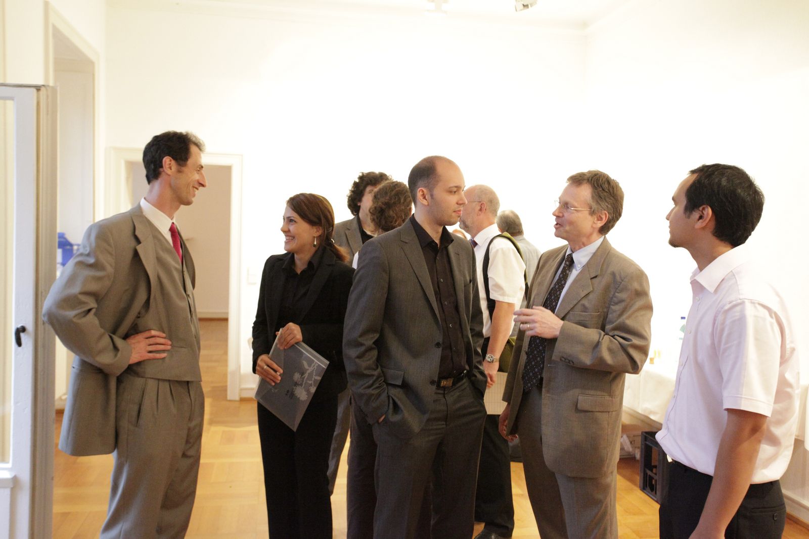 Professoren und Diplom-Absolventen unterhalten sich.