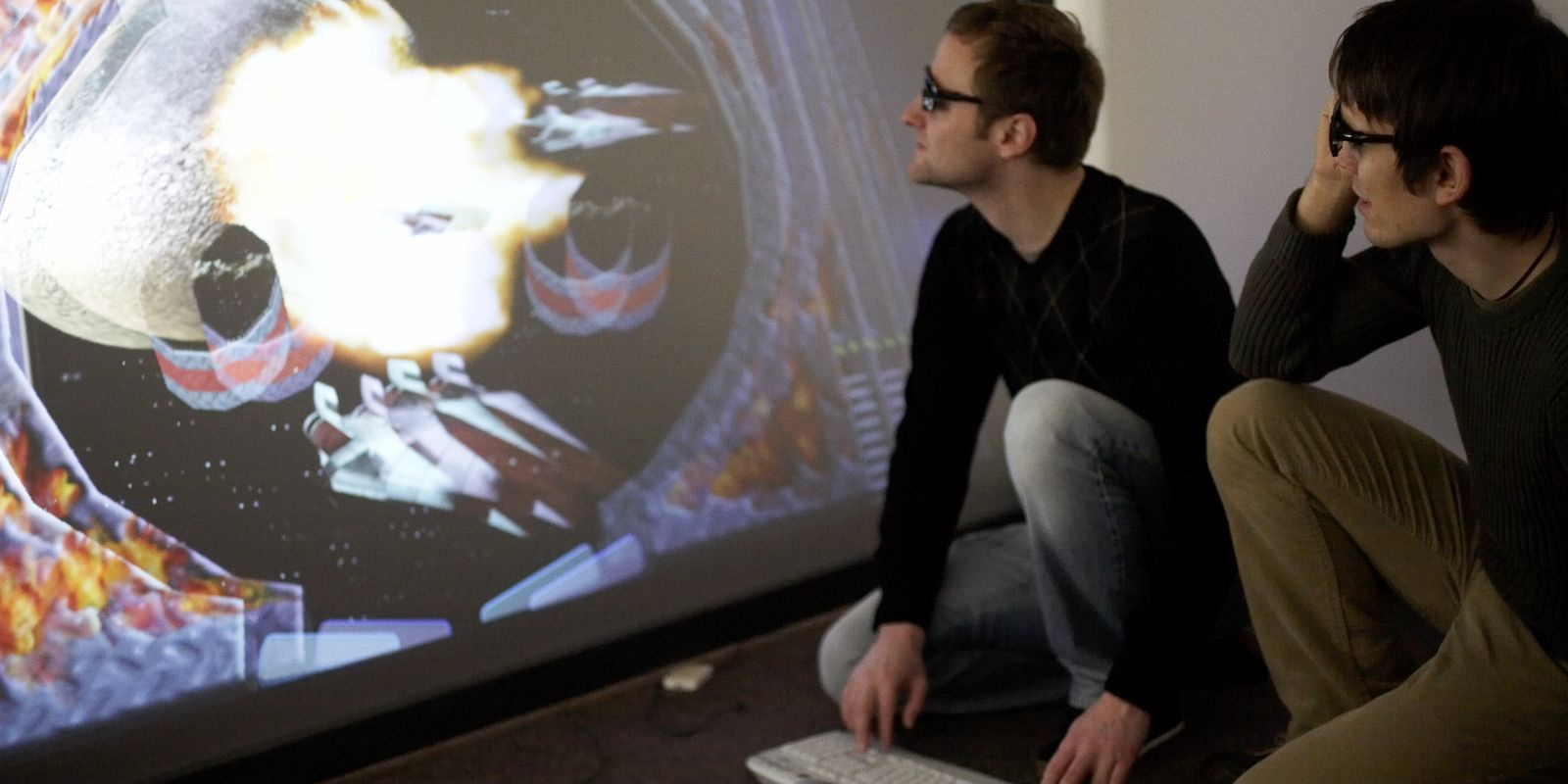 Zwei Studierende betrachten eine 3D-Grafik auf einer Leinwand.