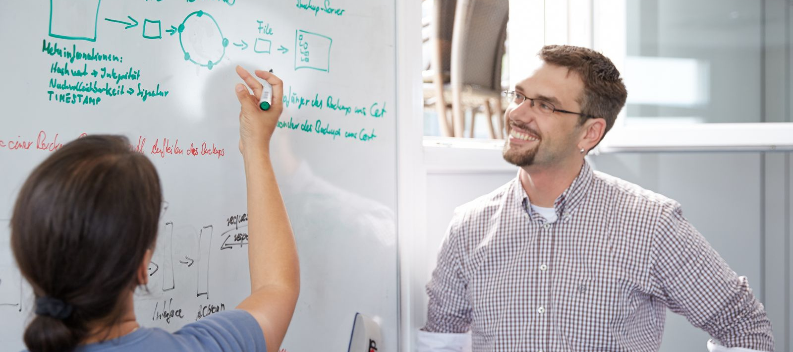 Eine Studierende erklärt etwas an einem Whiteboard.